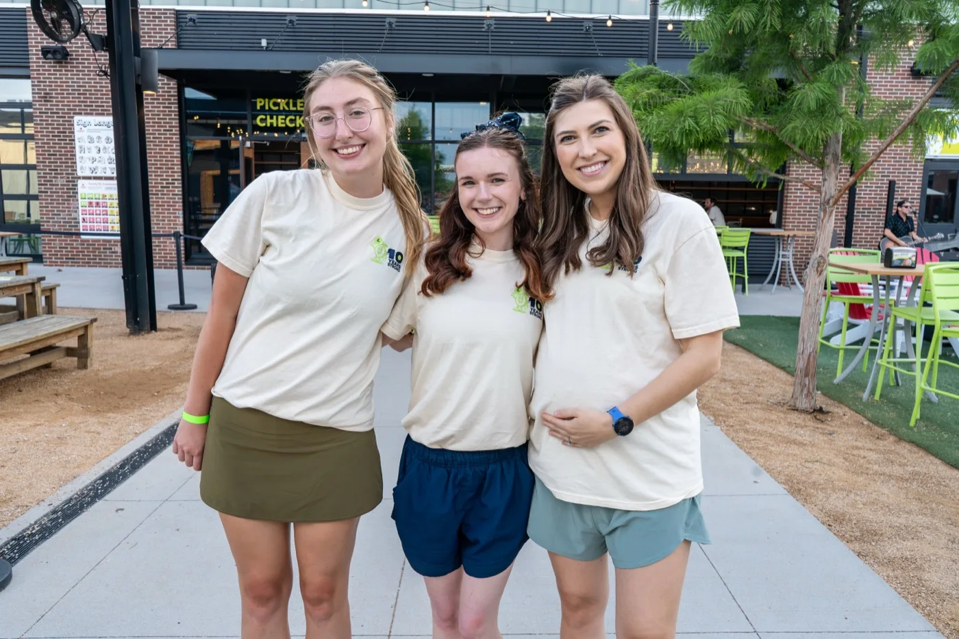 Three LimeLight teammates smiling together at an outdoor team event
