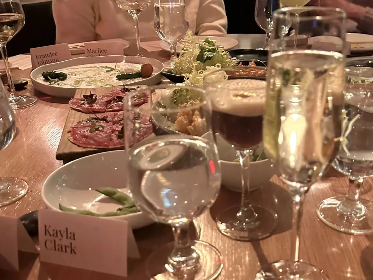 Shared plates, place cards and glasses on the table at a Women in Ecommerce dinner